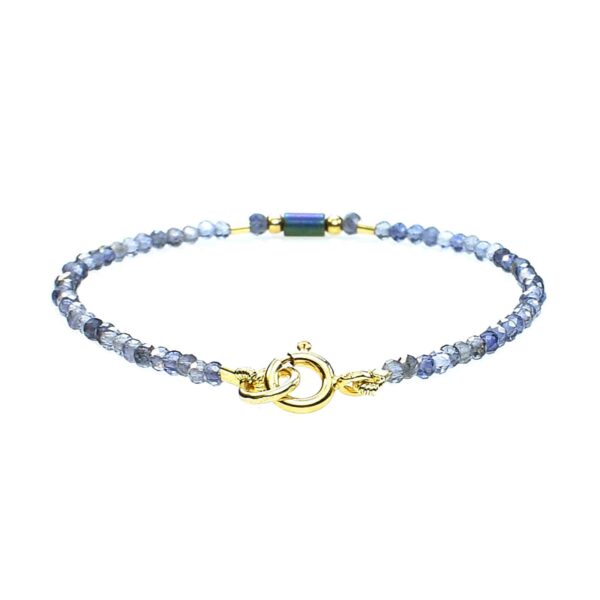 Handmade bracelet with natural, faceted, spherical shaped iolite gemstones and one cylindrical oxidized agate element in the center. The bracelet has decorative elements and clasp made from gold plated sterling silver.