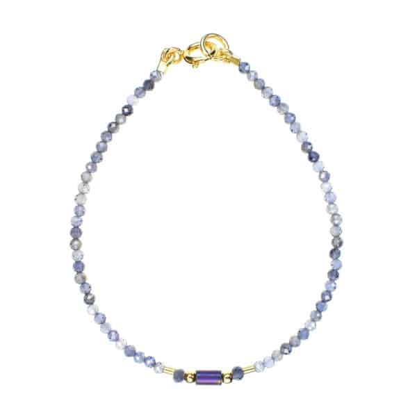 Handmade bracelet with natural, faceted, spherical shaped iolite gemstones and one cylindrical oxidized agate element in the center. The bracelet has decorative elements and clasp made from gold plated sterling silver.