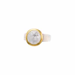 Δαχτυλίδι από ασήμι 925 και φυσική πέτρα λευκού Λαμπραδορίτη στρογγυλού σχήματος. Η επιφάνια της γάμπας είναι σαγρέ και το περίγραμμα του καστονιού είναι επιχρυσωμένο. Αγοράστε online shop.