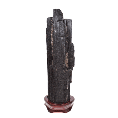 Raw piece of natural black tourmaline gemstone, with a size of 32cm. The tourmaline is placed on a wooden base. Buy online shop.