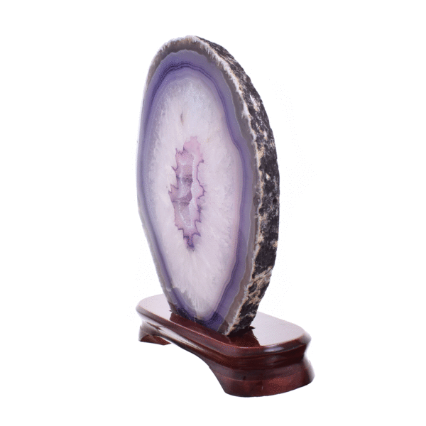 Slice of natural agate gemstone with crystal quartz, painted purple and polished on the one side. The slice of agate is placed on a wooden base and it has a height of 20cm. Buy online shop.