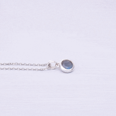 Handmade pendant made of sterling silver and natural, faceted labradorite gemstone in a round shape. The pendant is threaded on a sterling silver chain. Buy online shop.