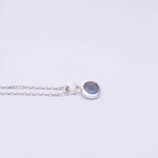 Handmade pendant made of sterling silver and natural, faceted labradorite gemstone in a round shape. The pendant is threaded on a sterling silver chain. Buy online shop.