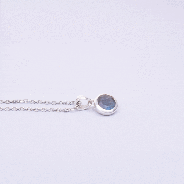 Handmade pendant made of sterling silver and natural, faceted labradorite gemstone in a round shape. The pendant is threaded on a sterling silver chain. Buy online shop.