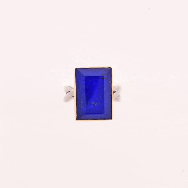 Handmade sterling silver and gold ring with doublet made of crystal quartz and lapis lazuli gemstones, in a parallelogram shape. The band of the ring is made of sterling silver and the outline of the bezel is made of 18 carats gold. The doublet consists of two layers of stones. The upper stone is crystal quartz and the stone at the bottom is lapis lazuli.