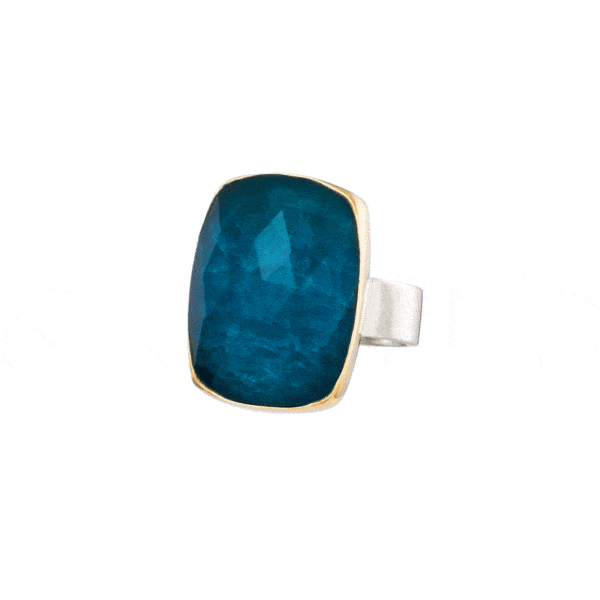 Handmade silver and gold ring with doublet made of crystal quartz and apatite, in a parallelogram shape. The bezel of the ring is made of 18 carats gold and the band is made of sterling silver. The doublet consists of two layers of stones. The upper stone is crystal quartz and the stone at the bottom is apatite. Buy online shop.