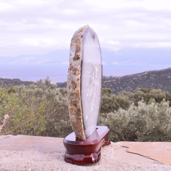 Slice of natural Agate gemstone with crystal quartz, placed on a wooden base. The Agate is polished on both sides and it has a height of 19cm. Buy online shop.