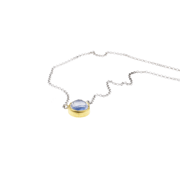 Handmade sterling silver pendant with doublet made of Crystal Quartz and Kyanite, in a round shape. The doublet consists of two layers of stones. The upper stone is Crystal Quartz and the stone at the bottom is Kyanite. The pendant has gold plated silver bezel and embedded sterling silver chain. Buy online shop.