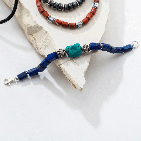 Handmade bracelet with natural lapis lazuli gemstones and one central turquoise gemstone, threaded on a blue string in which there are some knots between the stones. The bracelet is decorated with elements made of sterling silver and it has a sterling silver clasp. Buy online shop.