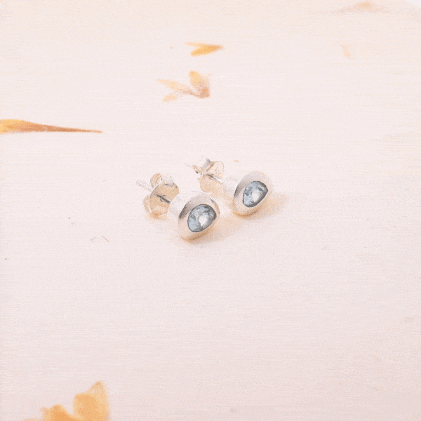 Handmade studded earrings made of sterling silver and natural blue topaz gemstone in a rteardrop shape. Buy online shop.