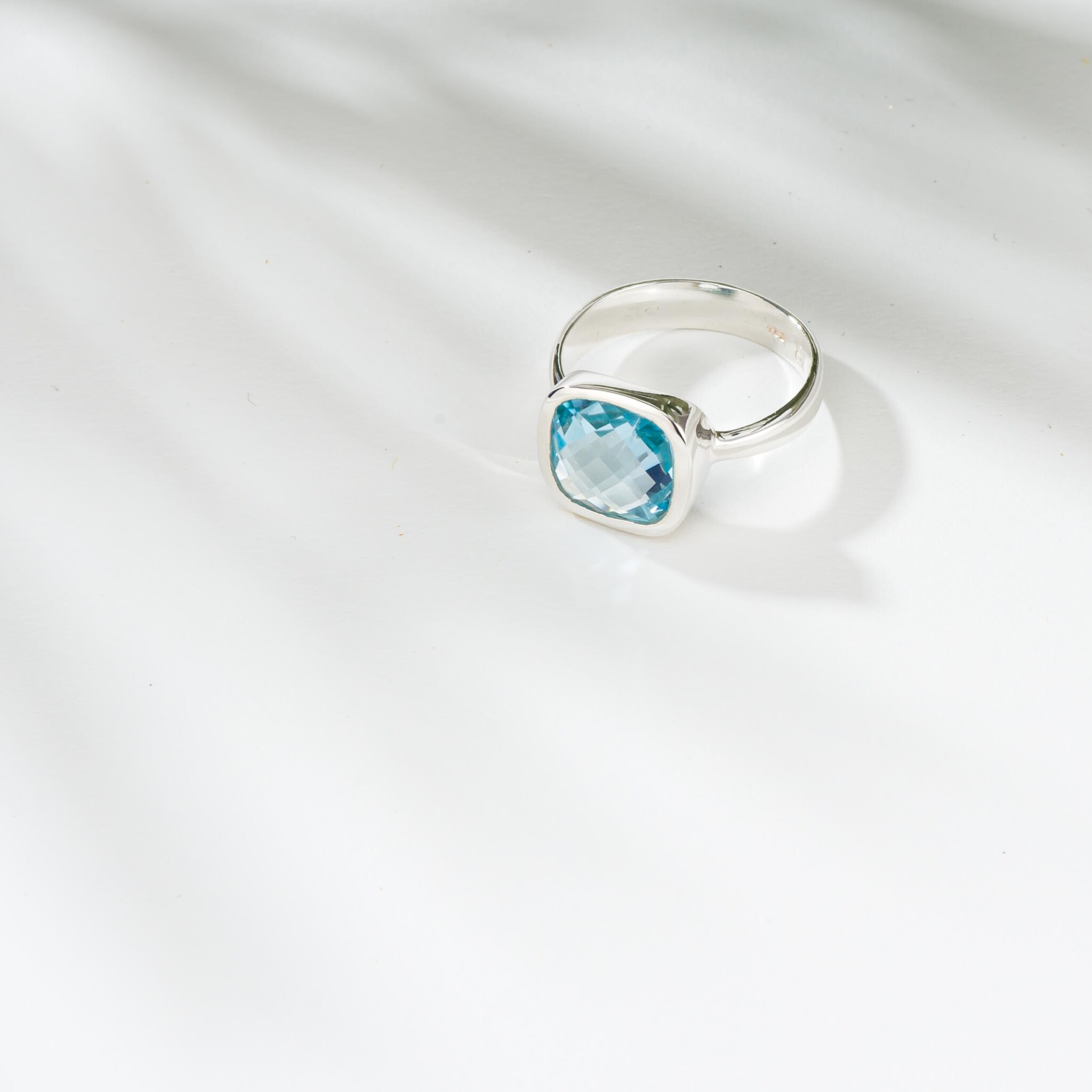 Silver ring with blue topaz gemstone in a square shape