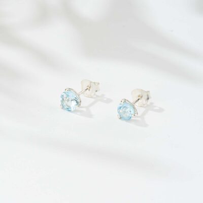 Handmade stud earrings made of sterling silver and natural blue topaz gemstone in a round shape. Buy online shop.