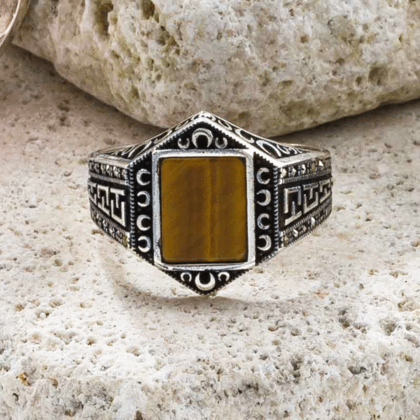 Handmade ring made of sterling silver and tiger eye gemstone, in a parallelogram shape. On the band of the ring there are small marcasite gemstones. Buy online shop.