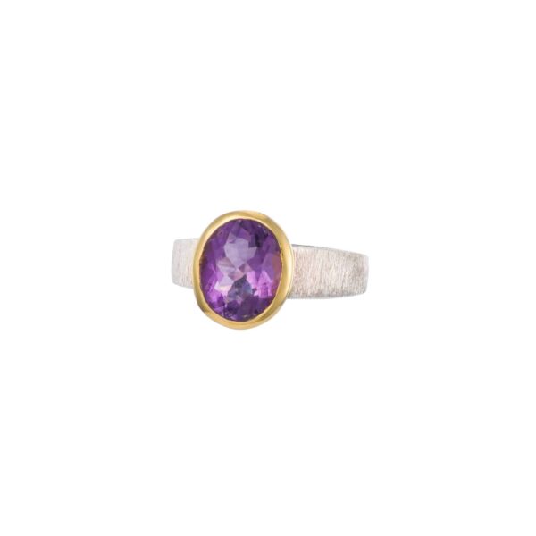 Handmade ring made of sterling silver and natural amethyst gemstone in an oval shape. The ring has textured band and gold plated bezel. Buy online shop.