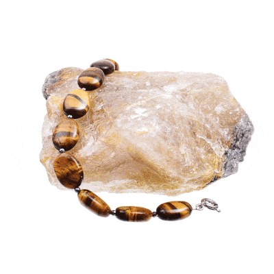 Handmade bracelet with natural tiger's eye gemstones in an oval shape and faceted pyrite gemstones in a spherical shape. The bracelet has a clasp made from sterling silver. Buy online shop.