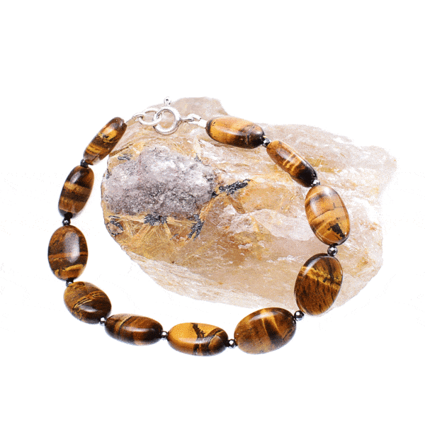 Handmade bracelet with natural tiger's eye gemstones in an oval shape and faceted pyrite gemstones in a spherical shape. The bracelet has a clasp made from sterling silver. Buy online shop.