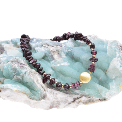 Handmade bracelet with small, polished pieces of natural garnet gemstone in an irregular shape and faceted pyrite gemstones in a spherical shape. The bracelet has decorative elements and clasp made from gold plated sterling silver. Buy online shop.