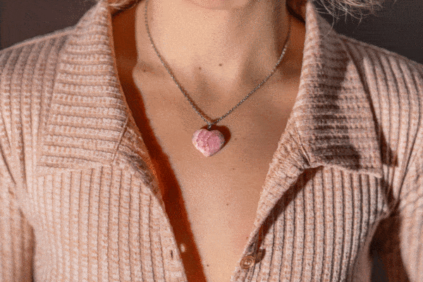 Pendant made from natural Rhodochrosite gemstone in heart shape. The pendant is worn on a handmade sterling silver chain. Buy online shop.