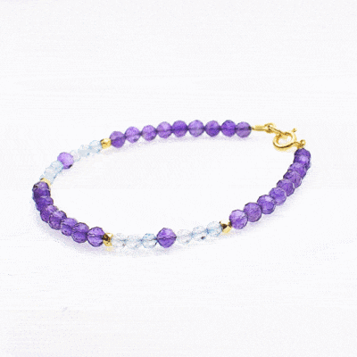 Handmade bracelet made of natural, faceted amethyst and blue topaz gemstones, in a spherical shape. The bracelet has a clasp and decorative elements made from gold plated sterling silver. Buy online shop.