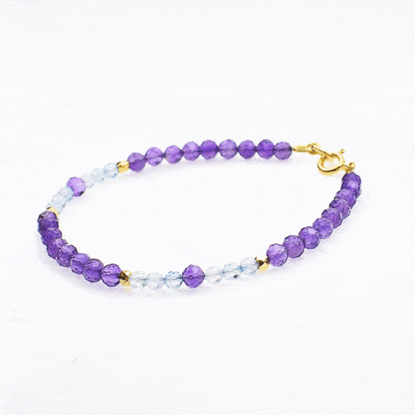 Handmade bracelet made of natural, faceted amethyst and blue topaz gemstones, in a spherical shape. The bracelet has a clasp and decorative elements made from gold plated sterling silver. Buy online shop.