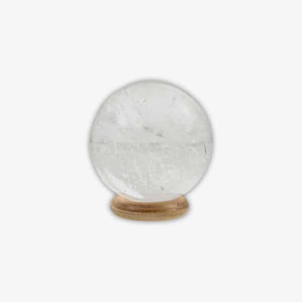 Γυαλισμένη σφαίρα από φυσικό Κρύσταλλο Χαλαζία με διάμετρο 5cm. Η σφαίρα συνοδεύεται από μια ξύλινη βάση. Αγοράστε online shop.