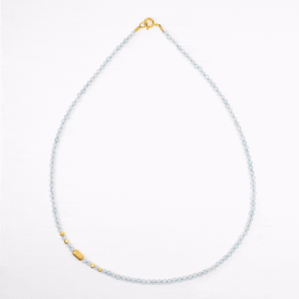 Handmade necklace with natural, faceted blue topaz gemstones in a spherical shape and decorative gold plated sterling silver elements.