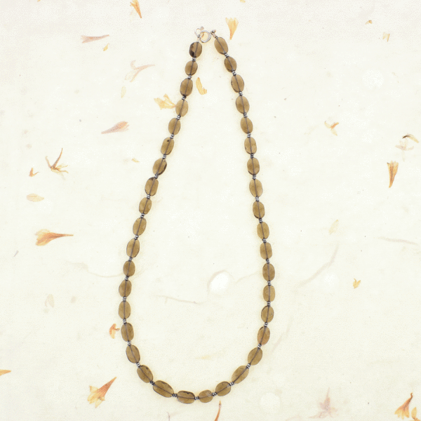 Handmade necklace with natural oval and wheel shaped smoky quartz and hematite gemstones. The necklace has a sterling silver clasp.
