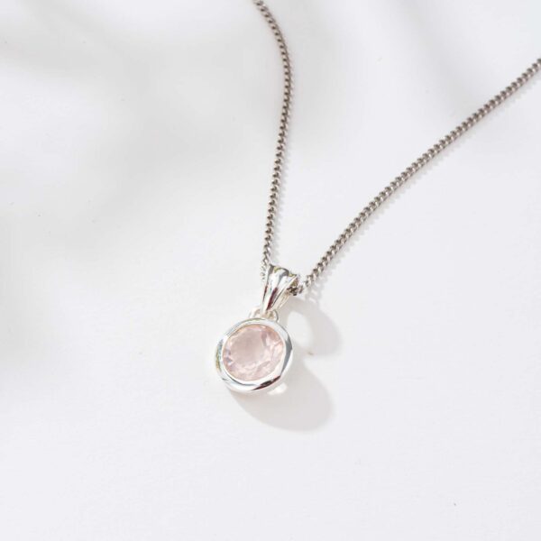 Handmade sterling silver pendant with natural, round shaped rose quartz gemstone, threaded on a sterling silver chain.
