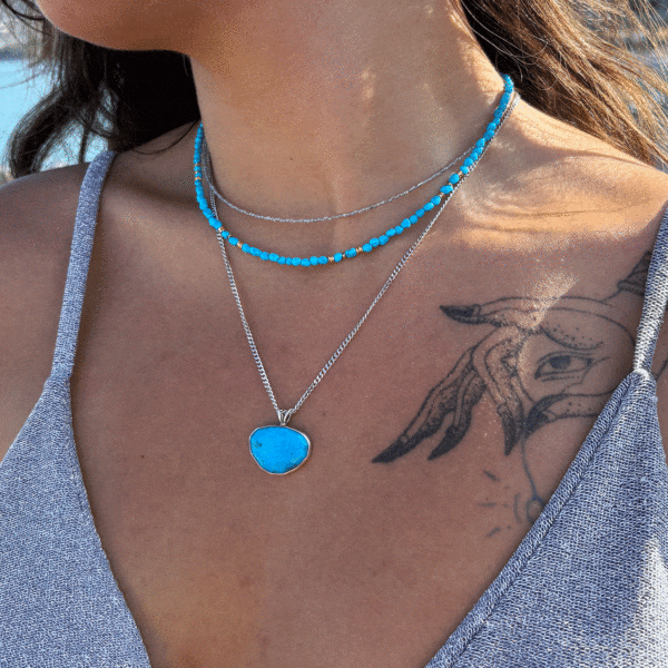 Handmade sterling silver pendant featuring a natural, irregular-shaped Turquoise stone, threaded on a fine silver chain.