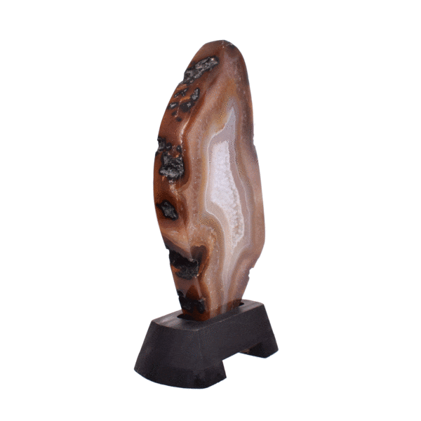 Polished slice of natural agate gemstone with crystal quartz, in warm earthy tones. Mounted on a black wooden base, this elegant piece stands 22cm tall.